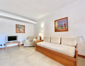 a living room with a couch and a tv at Alvaflor - Vilamoura in Vilamoura