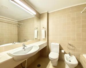 a bathroom with a sink and a toilet and a mirror at Alvaflor - Vilamoura in Vilamoura