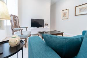 sala de estar con muebles azules y TV en Apartamento Cadiz Wonderland, en Cádiz
