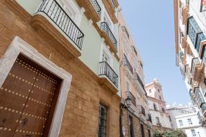 een gebouw met een houten deur op een straat bij Apartamento Cadiz Wonderland in Cádiz