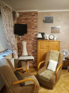 uma sala de estar com duas cadeiras e uma televisão em Kwatera na Bagnach em Osowiec