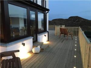 a deck with a bench and a chair on a house at Ceol na Mara Guest House in Tarbert