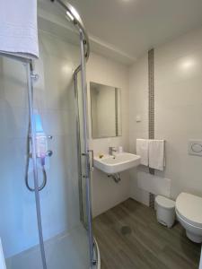 a bathroom with a shower and a sink and a toilet at Stella di Mare Alojamento Local in Figueira da Foz +99 photos