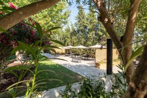 a patio with tables and umbrellas in a park at Manta Guest in Manta Rota