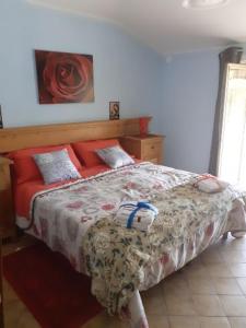 sypialnia z dużym łóżkiem z czerwonymi poduszkami w obiekcie LA CASA DEI CILIEGI w mieście Brossasco