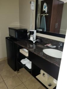 a bathroom with a sink and a microwave at Super 8 by Wyndham Los Angeles-Culver City Area in Los Angeles