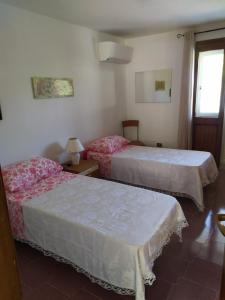 1 dormitorio con 2 camas y ventana en Mare Natura, en Castelsardo