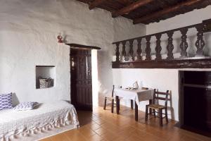 a bedroom with a bed and a table and chair at Koutsounari Traditional Cottages in Koutsounari