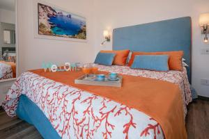 1 dormitorio con 1 cama grande con almohadas de color naranja y azul en Maison Cipriani, en SantʼAgata sui Due Golfi