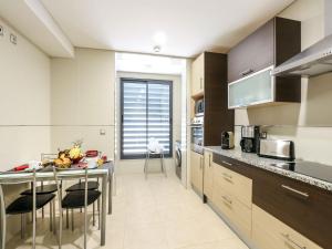 a kitchen with a counter and a table with chairs at V4, Villa Jardins Branqueira near Beach, Albufeira in Albufeira