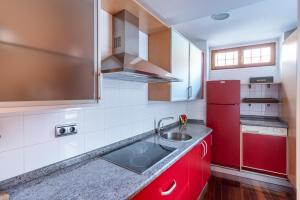 uma cozinha com um lavatório e um frigorífico vermelho em Housingleón - Galeria em Leão
