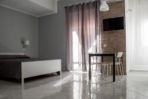 1 dormitorio con 1 cama, mesa y sillas en Una finestra sul glicine, en Cirò Marina