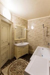y baño con bañera, lavabo y espejo. en Residential complex Central 271, en Almaty