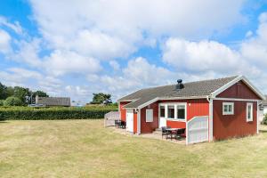 una pequeña casa roja con césped delante en First Camp Björkäng-Varberg en Tvååker