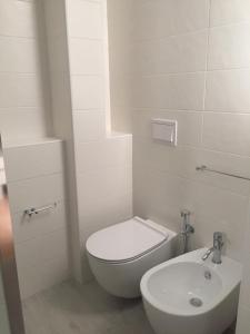 ein weißes Bad mit einem WC und einem Waschbecken in der Unterkunft Ugento Dimora in Ugento