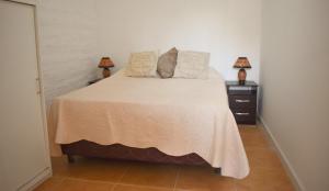 a bedroom with a large bed with two night stands at Atlantida casi en la playa in Atlántida