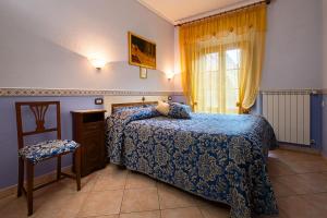 a bedroom with a bed and a window and a chair at B&B Locanda Il Tufo Rosa in Pitigliano