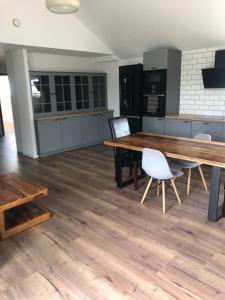 uma grande cozinha com uma mesa de madeira e cadeiras em Przytulny domek z ogrodem, parkingiem oraz innymi udogodnieniami em Malbork