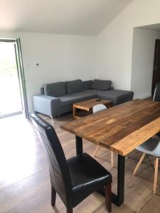 sala de estar con mesa de madera y sofá en Przytulny domek z ogrodem, parkingiem oraz innymi udogodnieniami en Malbork