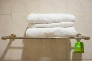 a pile of towels on a towel rack in a bathroom at City Residence Kutai 32 in Surabaya