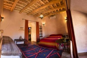 - une chambre avec un lit et une table dans l'établissement Dar Bladi, à Ouarzazate