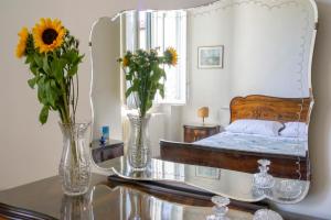 a bedroom with a bed and two vases with flowers on a table at L'OZioRinco Apartments in Florence