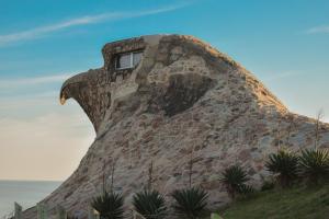 a building with a window on top of a rock wall at Atlantida casi en la playa in Atlántida