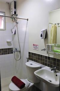 a bathroom with a shower and a toilet and a sink at The Studio 18 Residences in Manila