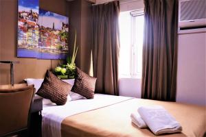 a hotel room with a bed with a window at The Studio 18 Residences in Manila