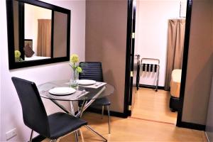a dining room with a table and chairs and a mirror at The Studio 18 Residences in Manila