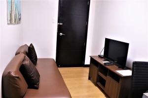 a living room with a couch and a tv at The Studio 18 Residences in Manila