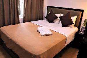 a bedroom with a bed with a towel on it at The Studio 18 Residences in Manila