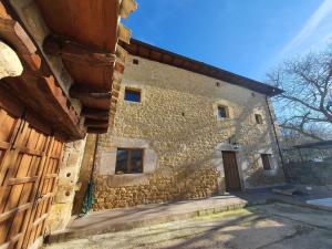 duży kamienny budynek z drewnianymi drzwiami w obiekcie CASA RURAL PALACIO LOS LABREQUINES w mieście Villacomparada de Rueda
