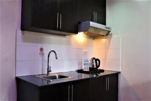 a kitchen with a sink and a microwave at The Studio 18 Residences in Manila
