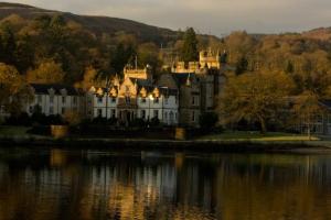 a large castle sitting next to a body of water at Cameron House Lodge on Loch Lomond in Balloch