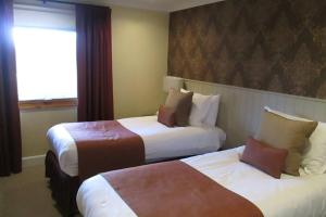 a hotel room with two beds and a window at Cameron House Lodge on Loch Lomond in Balloch