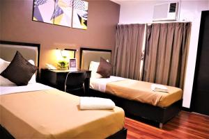 a hotel room with two beds and a desk at The Studio 18 Residences in Manila