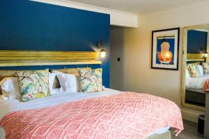 a bedroom with a large bed with a blue wall at The Bunk Inn in Newbury