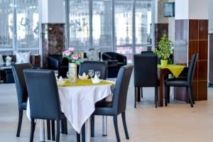 a dining room with a yellow table and chairs at Pensiune Roata Cu Noroc in Sighetu Marmaţiei +35 photos