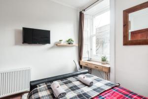 1 dormitorio con 1 cama y TV en la pared en City Centre Stylish Apartment at The Meadows Park, en Edimburgo