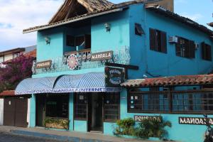 a blue building with a store in a street at Pousada Mandala in Búzios