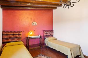 a room with two beds and a red wall at Casa Vacanze 4 Pileri in Cartabubbo