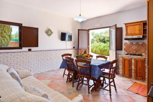 cocina y comedor con mesa y sillas en Casa Vacanze 4 Pileri, en Cartabubbo
