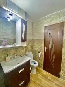 La salle de bains est pourvue d'un lavabo, de toilettes et d'une porte. dans l'établissement Apartament Sunshine, à Orşova