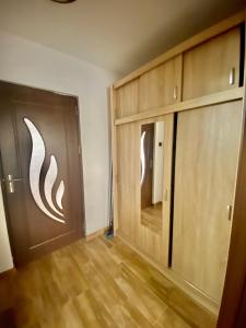 a room with two wooden doors and wooden floors at Apartament Sunshine in Orşova