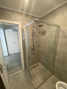 una ducha con puerta de cristal en un baño en DMApartmani, en Tuzla 21 fotos más