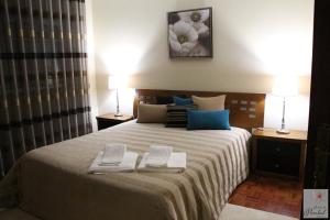 a bedroom with a large bed with two towels on it at Quinta do Pombal Douro in Penajoia +54 photos