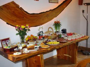a buffet of food on a wooden table at Les Chambres d'Hotes au Bois Fleuri in Roquebrune-sur-Argens