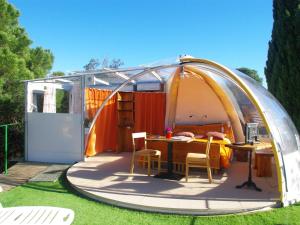 a tent with a table and chairs in a yard at Les Chambres d'Hotes au Bois Fleuri in Roquebrune-sur-Argens