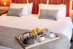 a tray with breakfast foods on a bed at Los Acebos Ushuaia Hotel in Ushuaia